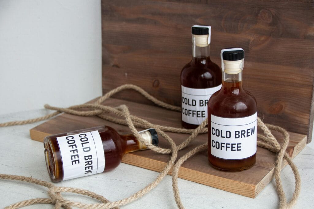 Three bottles of cold brew coffee arranged artistically on wooden boards with rope accents, conveying a rustic vibe.