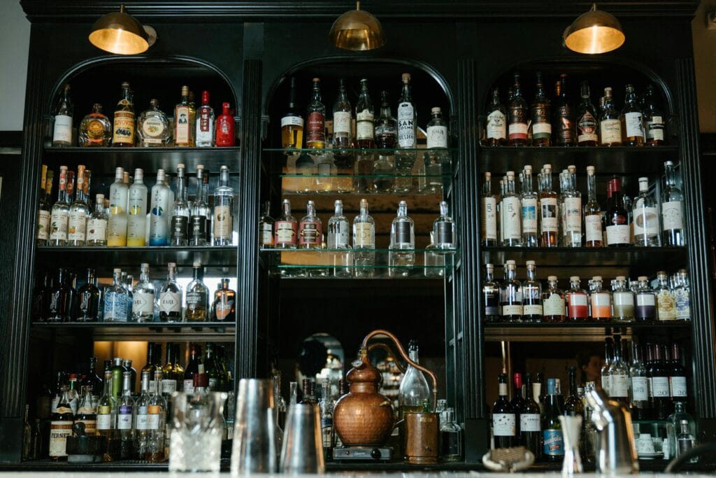 pexels-photo-4667030-4667030 Luxurious bar display stocked with a wide variety of liquor bottles, creating a classic and sophisticated atmosphere.